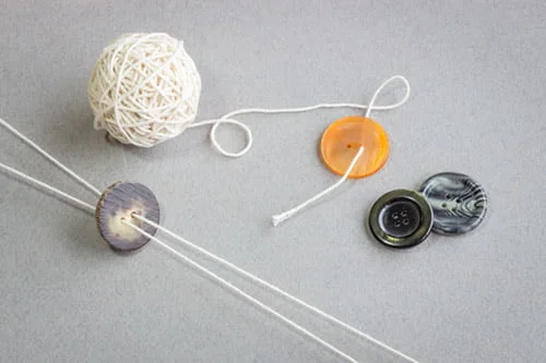 Nappihyrrä ja valmistusaineet: isoja nappeja ja kalalankaa.